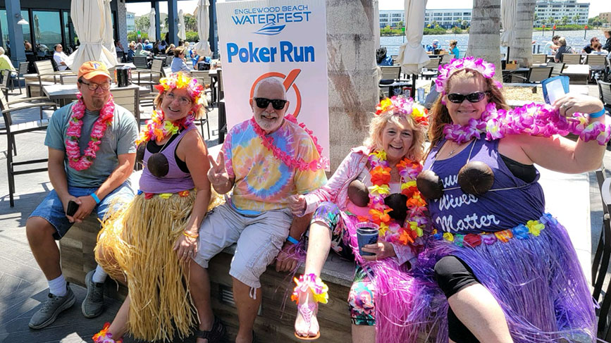 5 people wearing costume in front of Englewood Beach Waterfest Poker Run sign