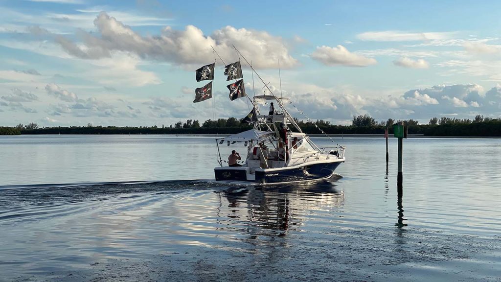 fishing boat with pirate flags driving away